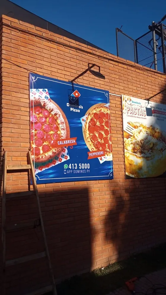 Dos carteles instalados en una pared de ladrillo
